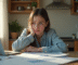 Jeune adulte inquiet avec documents financiers et ordinateur