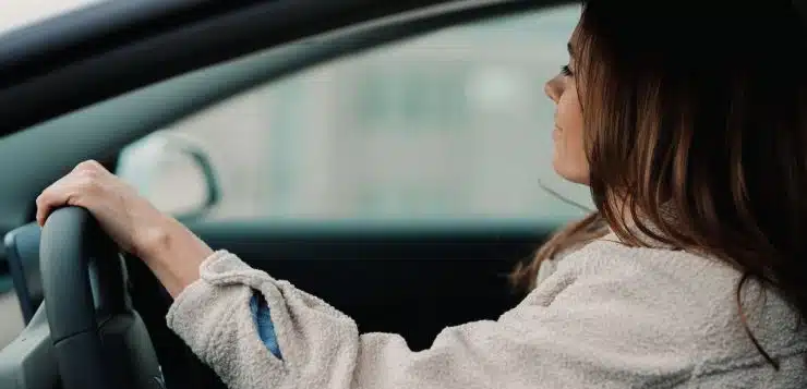 woman in gray hoodie sitting inside car during daytime